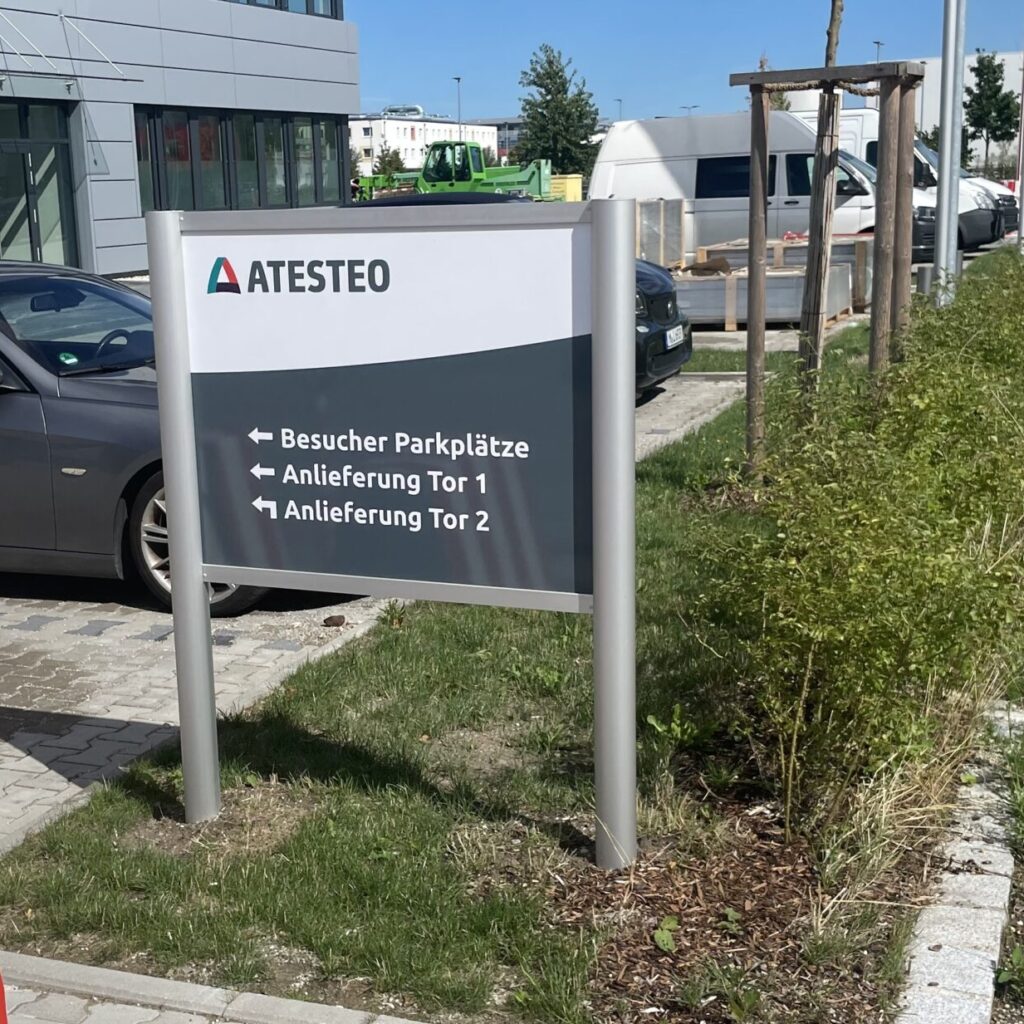 Beschilderung von ATESTEO mit Informationen zu Besucherparkplätzen und Anlieferung.