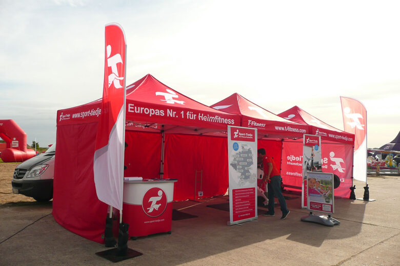 Rotes Faltzelt mit dem Logo von ISLINGER GmbH, das für Heimfitness wirbt.