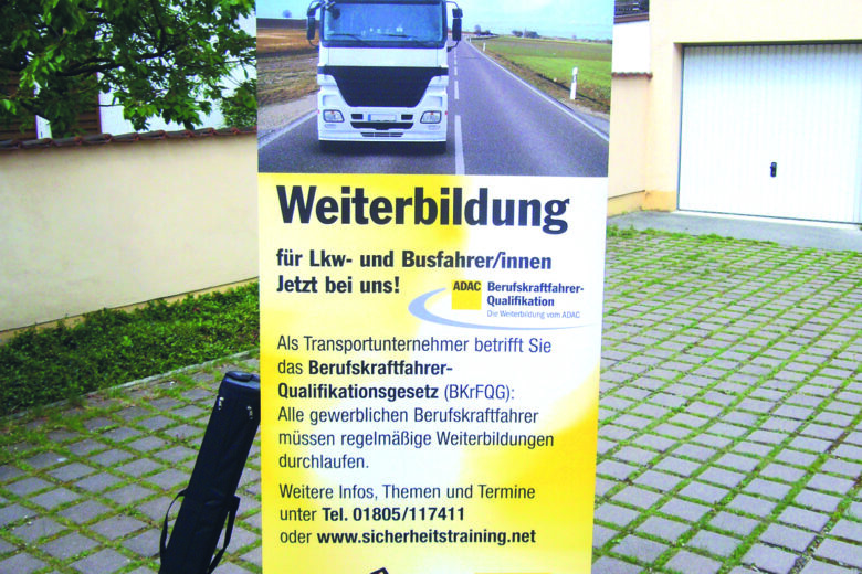 Rollup-Banner zur Weiterbildung für Lkw- und Busfahrer mit einem Lkw auf der Straße.